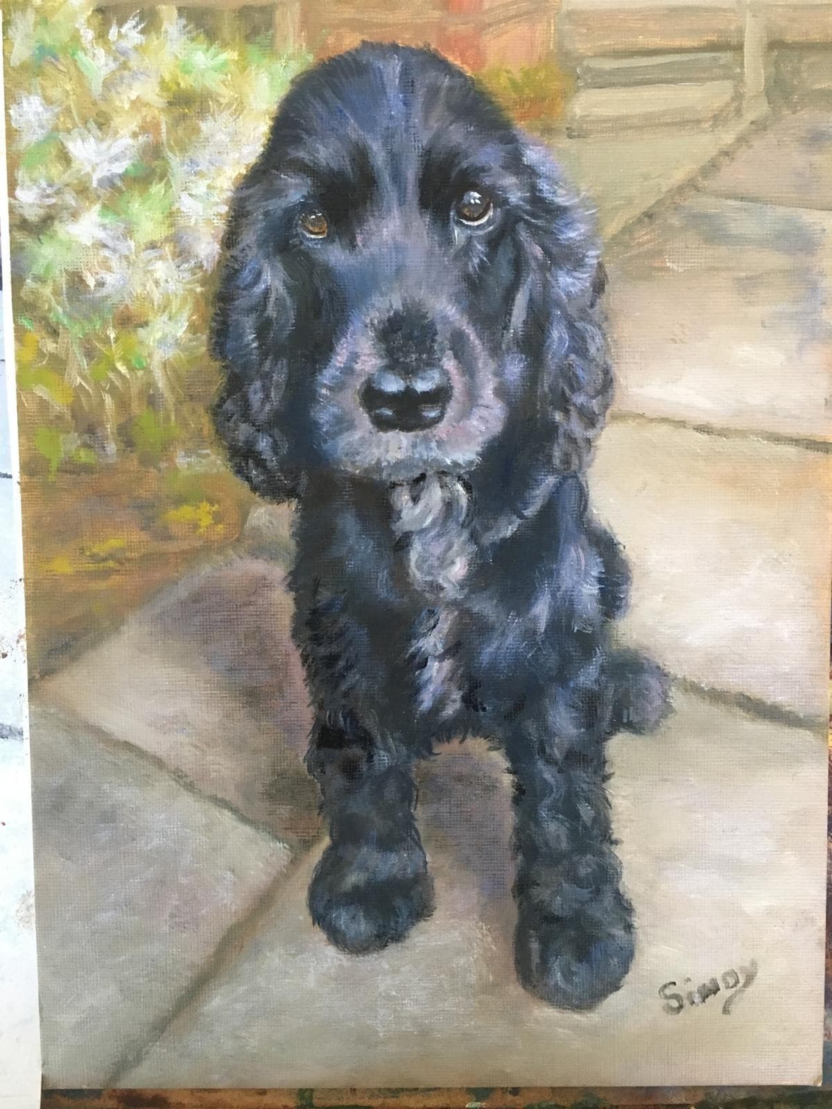 Oil painting of a black cocker spaniel sitting on a paved path, looking up with brown eyes